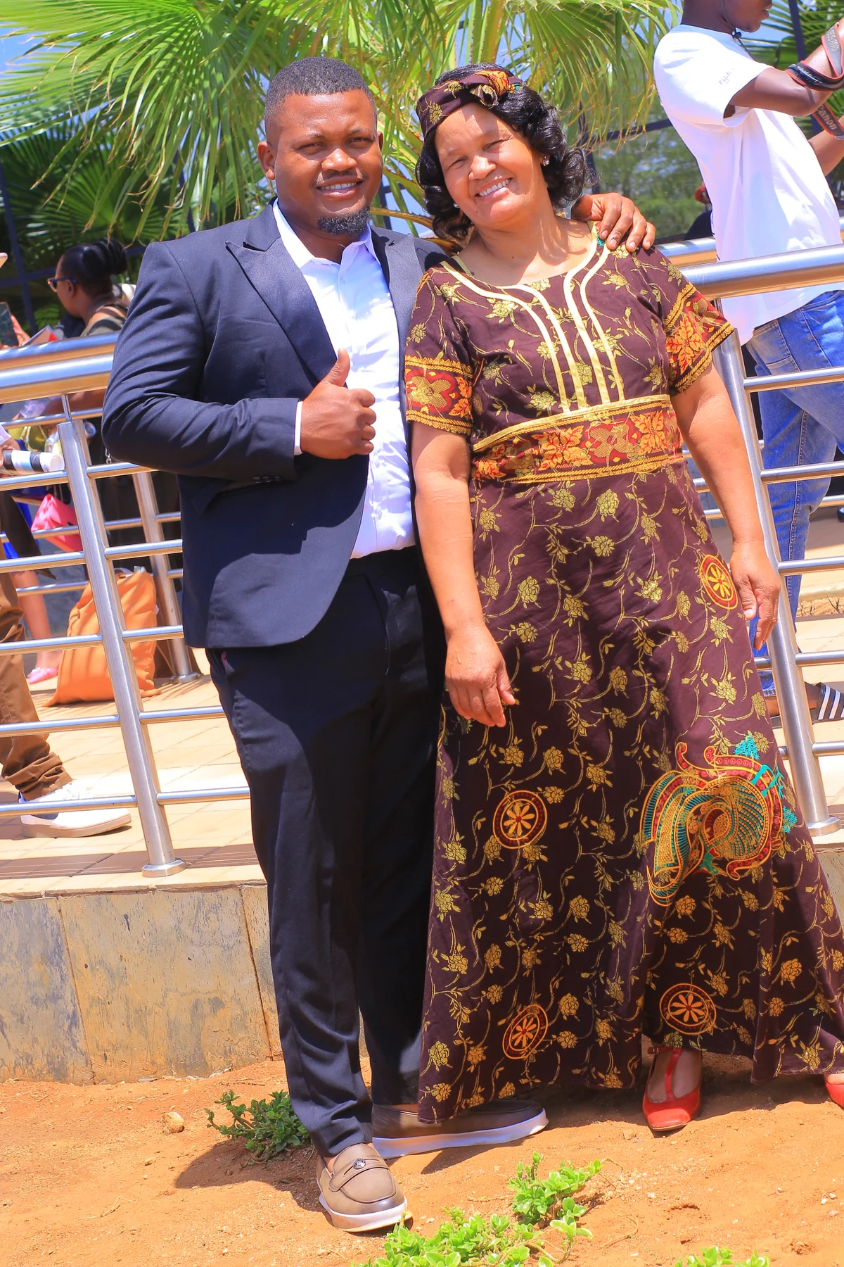 The founder of Autologic Motors standing with his mother